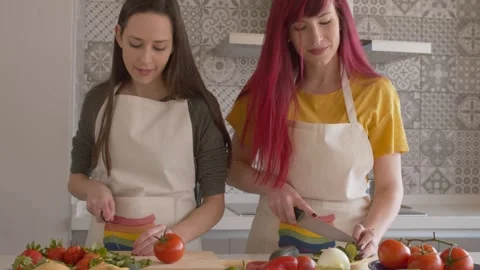 Two Women with Pride Aprons by Kitchen Counter 库存影片 334318468