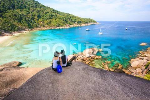 Two women relaxing on top of the rocks and enjoying the view of Similan Islan Stock Photos