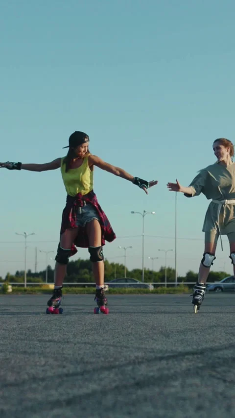 Two women rollerblade joyfully, showcasing friendship and fun Stock Footage 306616587