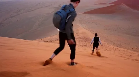 Two women run down the side of the highest dunes in the world! Stock Footage 43966607