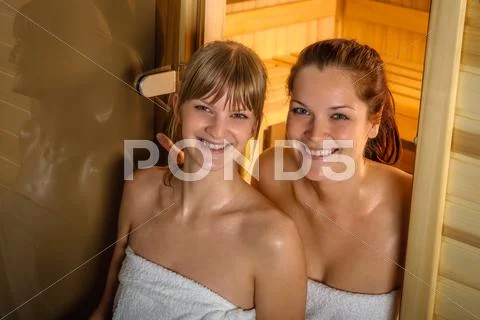 Two women at sauna wrapped in towel Stock Photos