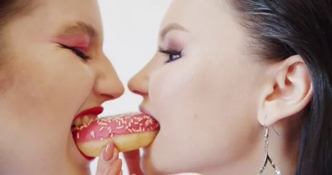 A Two Women Sharing a Donut Together in Joyful Moment Stock Footage 299615086