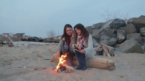 Two women sitting by the fire. BBQ picnic Vídeos de archivo 75801559