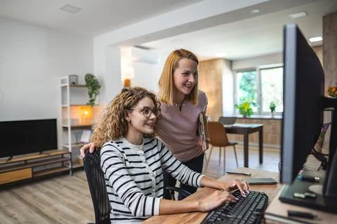 Two Women Sitting in Front of a Computer Monitor Stock Photos