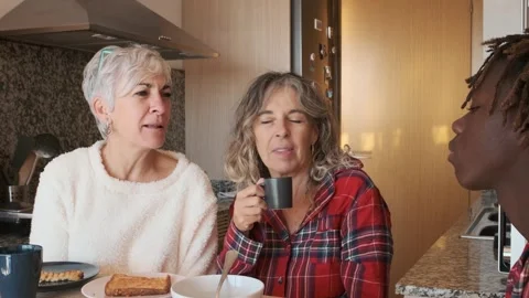 Two women smiling while enjoying having breakfast with their son at home. Stock Footage 246544828
