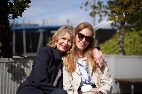 Two women smiling while posing together outdoors. Stock-Fotos