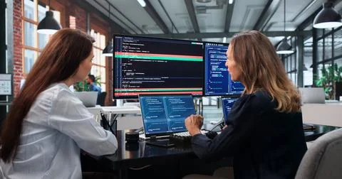 Two Women Software Developers Collaborate On Laptop Resolving Code Conflicts  스톡 사진