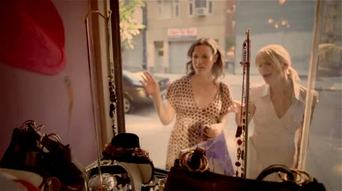 Two women standing outside store and looking in window Stock Footage 46257575