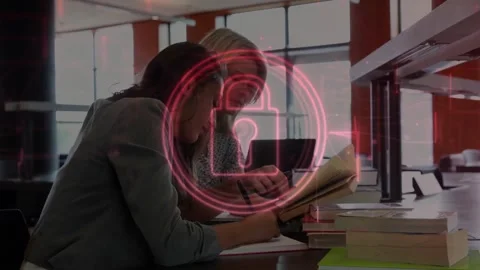Two women studying for exam at table, red lock graphic appearing over pair while Stock Footage 330729089