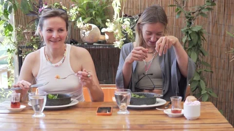 Two women in summer clothes having a fun breakfast in a restaurant in Turkey in Stock Footage 239326575