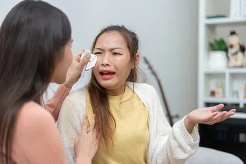 Two women talking about problems at home. Asian women embrace to calm their.. Stock Photos