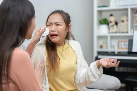 Two women talking about problems at home. Asian women embrace to calm their.. Foto stock