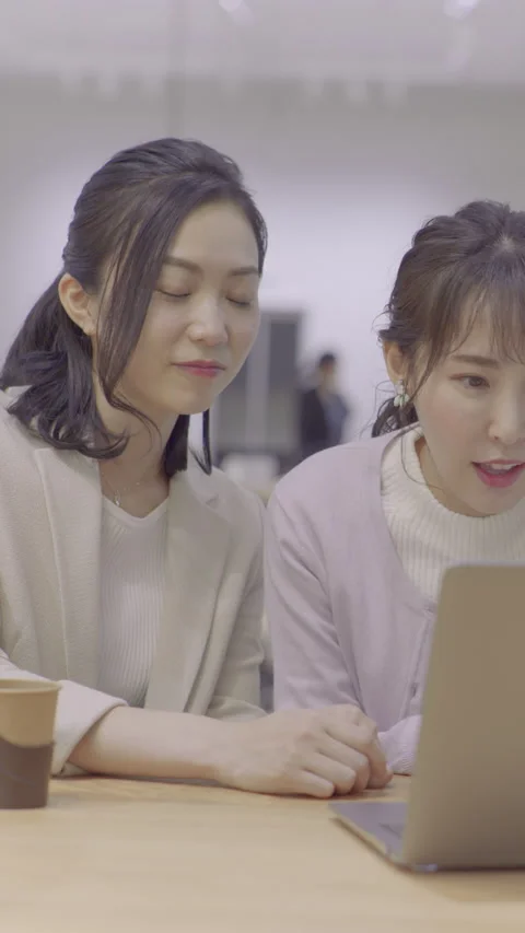 Two women talking while looking at a PC Stock Footage 162241835