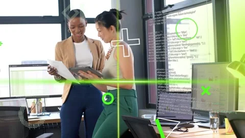Two women tapping tablet and pointing paper at tech desk starting green overlays Stock Footage 333735225