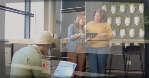 Two women tapping tablet, error overlays appearing over tech workspace, man Stock Footage 334307786
