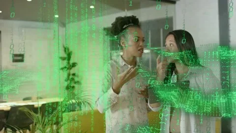 Two women tapping tablet gesturing and interacting with green overlay forming Stock Footage 335739505