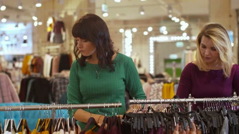Two women took the same shorts in a clothing store Stock Footage 119422617
