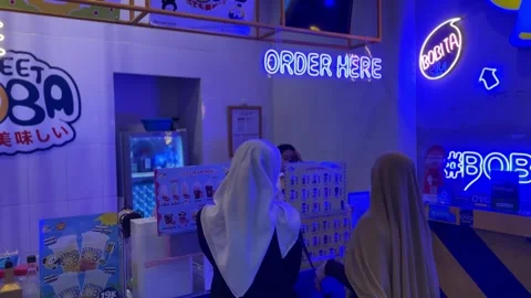 Two Women Using Hijab are Lining Up to Order Drinks at Street Bobba Store Stock Footage 244617547