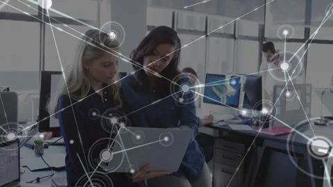 Two women using laptop pointing and starting network overlay expanding over work Stock Footage 331045550