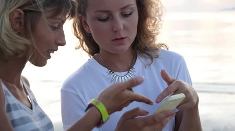 Two Women Using Mobile Phone Outdoors Video stock 58204471