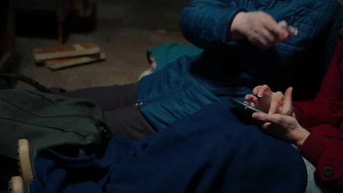 Two Women using a phone when hiding in a shelter 動画素材 171385725