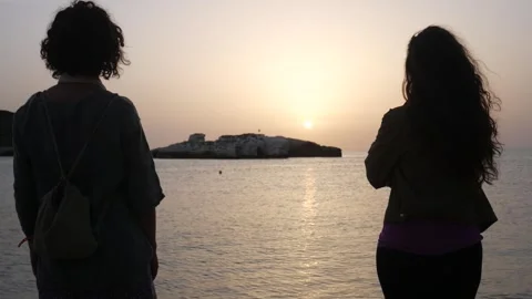 Two  women wait for the dawn on the Adriatic Sea and Campi island. Baia and C Stock Footage 283985725