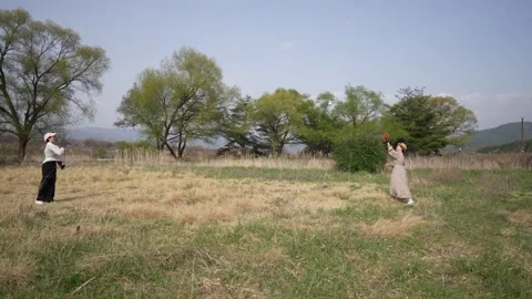 Two Women Walking Across an Open Meadow Stock Footage 346208306