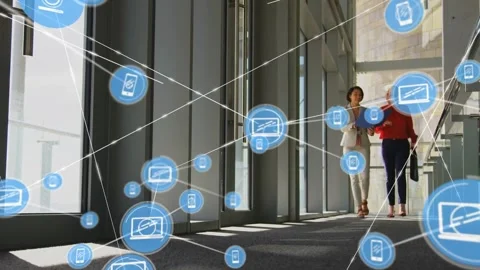 Two women walking hall reading blue folder, sparking device icons forming Stock Footage 334114245
