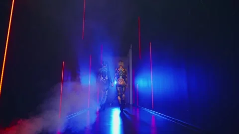 Two women walks studio full smoke, Fantasy cyborg woman robot costume metal Stock Footage 311820280