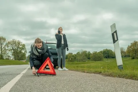 Two women wit a car breakdown on a road Stock Photos