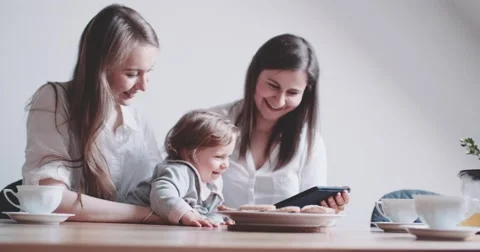 Two Women working on Laptop, holding baby girl. Slow Motion 4K DCi. 動画素材 63782002