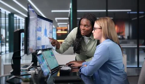 Two Women Working Together, Checking Financial Data On Laptop Screens. Stock Photos