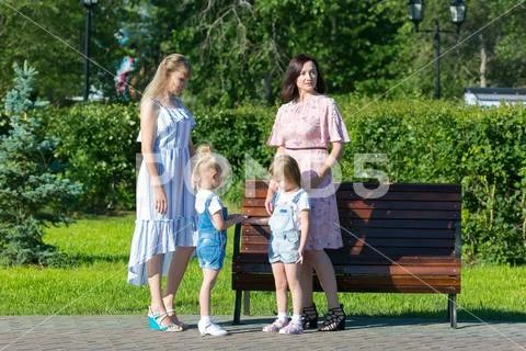 Two women with young children on the street.. Stock Photos