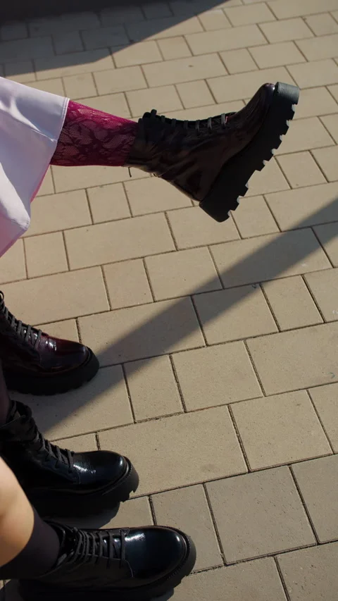 Two womens boots and shadows on sunlit pavement Stock Footage 320789334