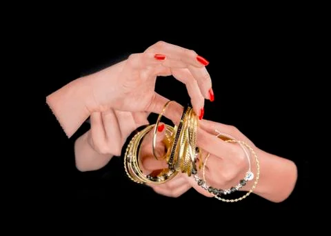 Two women's hands with golden bracelets Stock Photos