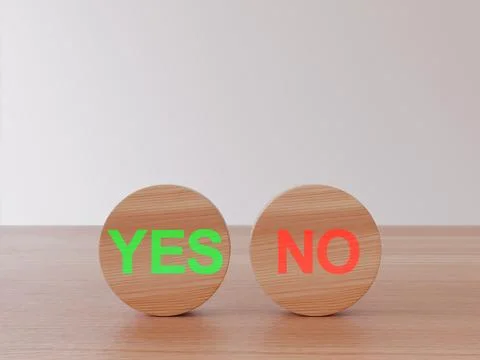 Two wooden circles placed on a surface with the green word yes and red word.. Stock Photos