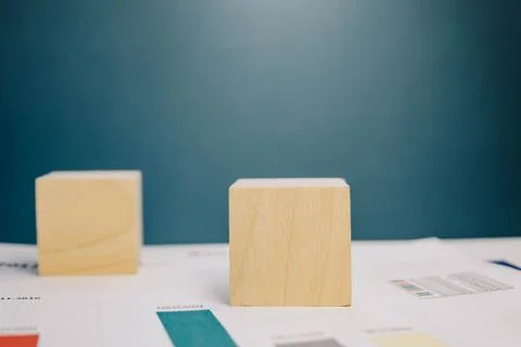 Two wooden cubes lying on a bundle of documents on a blue background Stock Photos