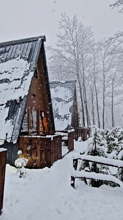 Two Wooden A Frame Cabins During Snowfall Video stock 326665313