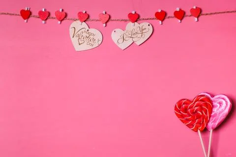 Two wooden hearts on a string Two red hearts on a clothespin Two lollipops. R Stock Photos