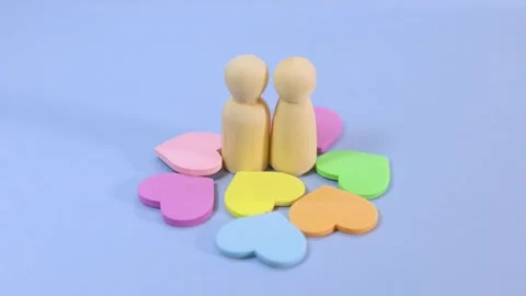 Two wooden peg dolls representing a couple standing together, surrounded by.. Video stock 327628760