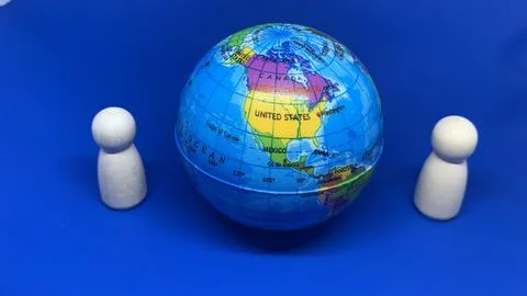 Two wooden peg figures positioned around a globe, Stock Photos