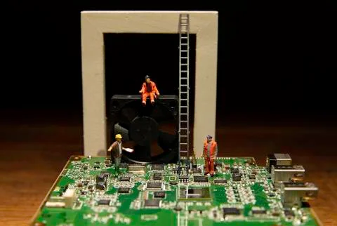 Two workers and one Foreman working on computer main board and black fan Stock Photos