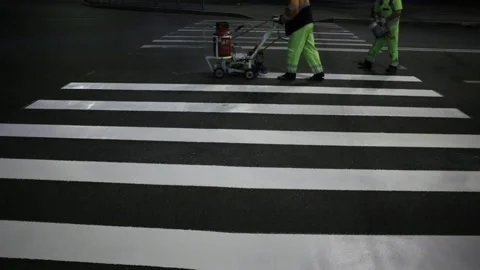 Two workers apply road markings on asphalt at night wide shot Stock Footage 221922537