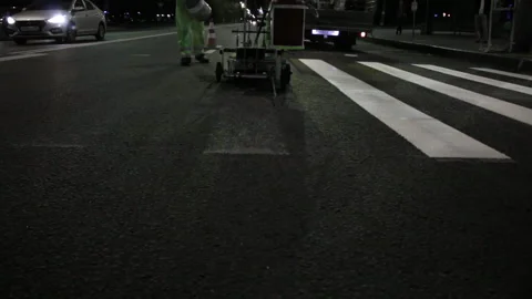 Two workers apply road markings on asphalt at night close up Stock Footage 221922829