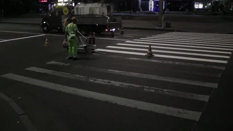 Two workers apply road markings on asphalt at night wide shot Stock Footage 222157557