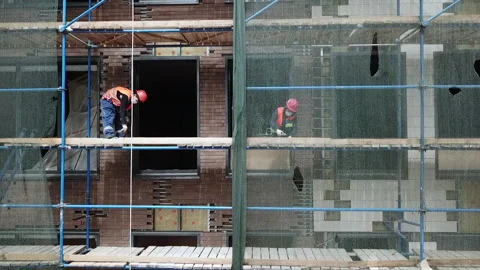 Two workers are finishing the facade of the building Stock Footage 231797798