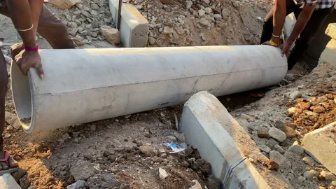 Two workers are installing concrete pipe on the side of the road Stock Footage 167516165
