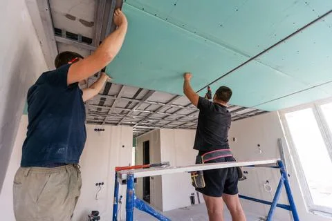 Two workers are mounted ceiling in the new flat 写真素材