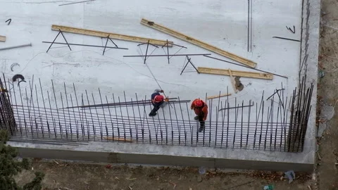 Two workers assembling a metal fence with bars at a construction site Stock Footage 236473061