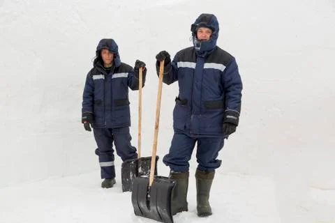 Two workers in blue jackets for snow removal 스톡 사진